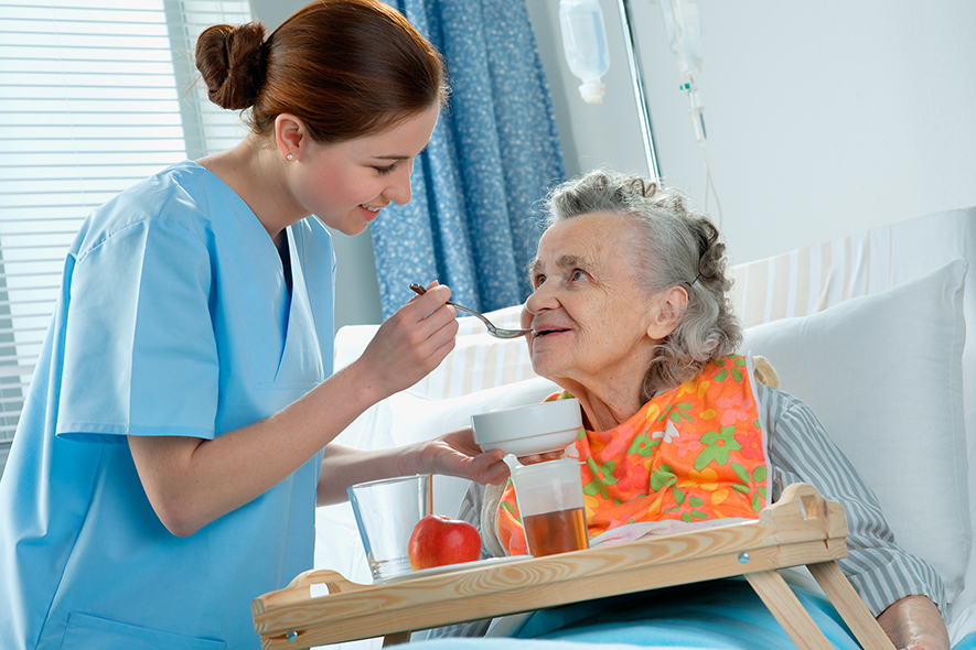 Caregiver feeding an elderly women