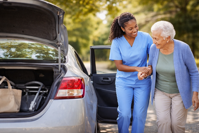 Caregiver helping elder patient get into the car.